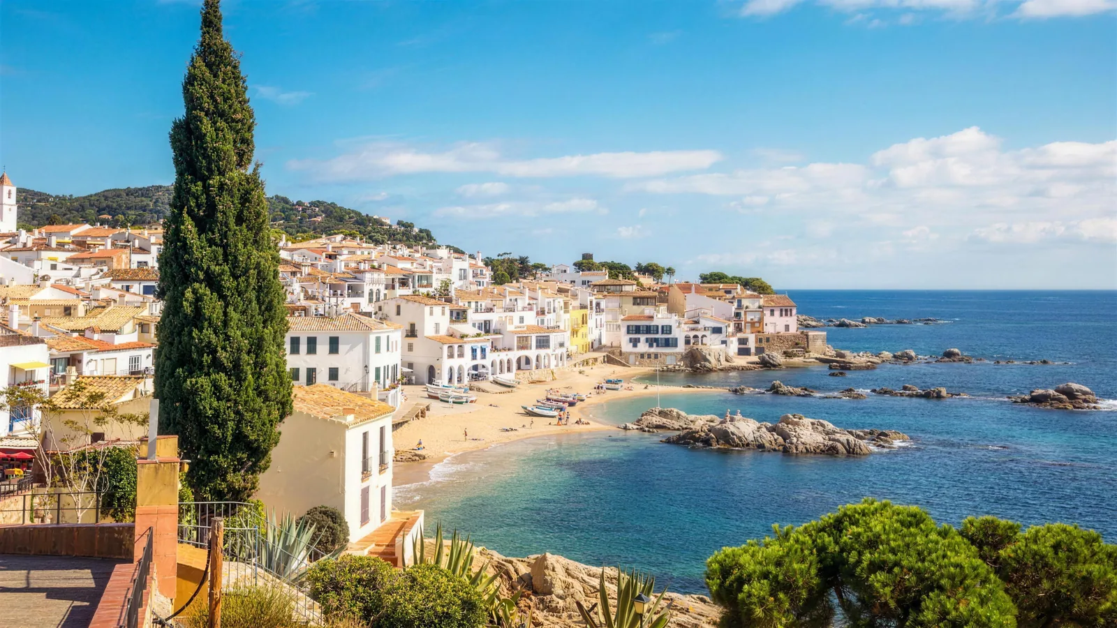 Weiße Häuser an einer Bucht mit türkisem Meer in Spanien